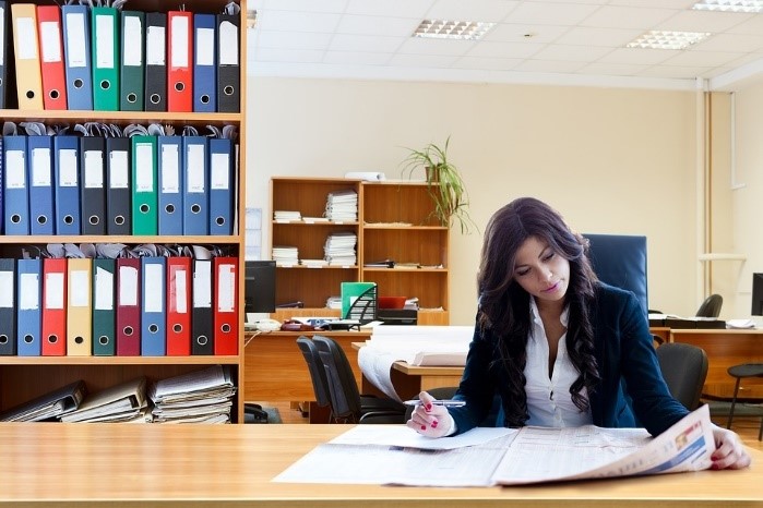 Persona sentada en un escritorio, realizando sus tareas y obligaciones correspondientes.