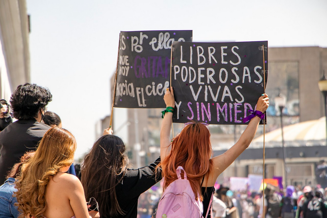Mujeres jóvenes con pancartas en una manifestación