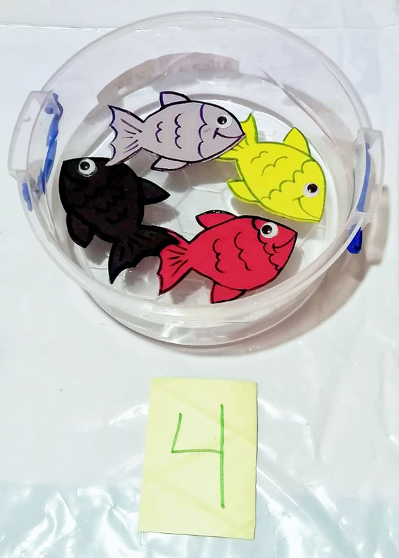 Traste de plástico con peces de fomi de colores y tarjeta con el número 4.