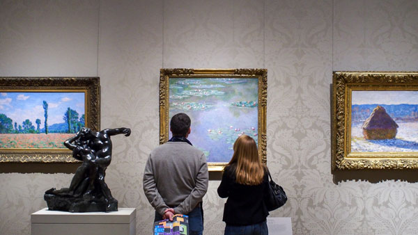 Dos visitantes observando obras impresionistas en el Museo de Boston, Estados Unidos