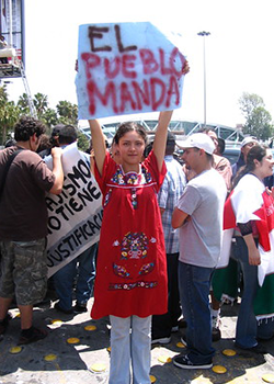 Mujer con cartel en manifestación.