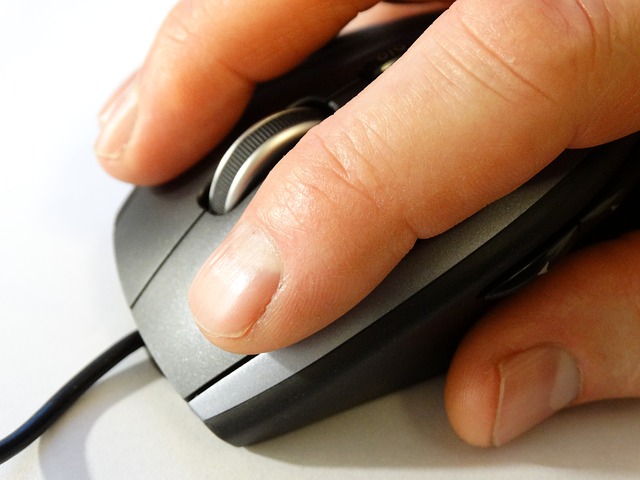 Se observa una mano de un individuo y un mouse de computadora.